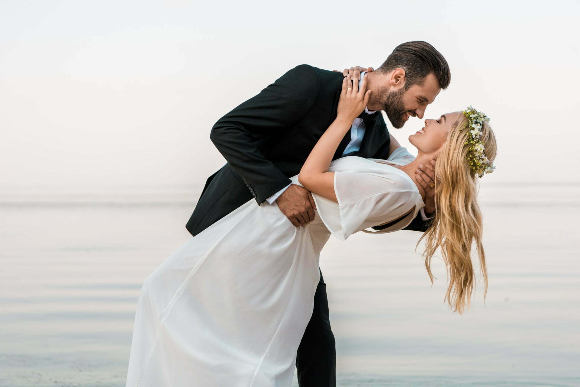 affectionate-wedding-couple-going-to-kiss-on-beach-5NLGSLQ.jpg